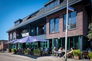 un grupo de personas sentadas en mesas fuera de un edificio en Hotel La Boutique, en Nijmegen