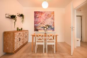 a dining room with a table and a painting at Urban Bliss - Contemporary Elegance in Modern Living Spaces in Voluntari