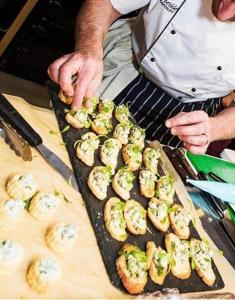 a man is preparing food on a tray at Donington Manor Hotel in Castle Donington