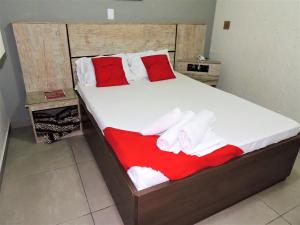 a bed with red and white towels on it at Hotel Vila Prudente São Paulo - By Up Hotel - fácil acesso Expo São Paulo e Museu Ipiranga in São Paulo