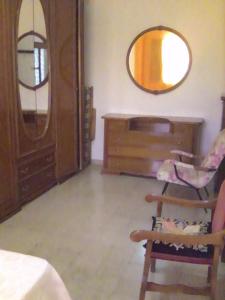 una stanza con specchio, sedia e cassettiera di Il Gelsomino a Custonaci