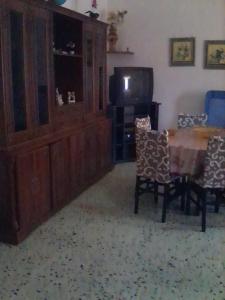 un soggiorno con tavolo, sedie e TV di Il Gelsomino a Custonaci