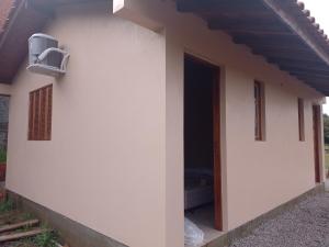 a side view of a white building with a door at Pousada Taiani in Itaara