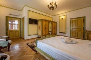 a bedroom with a large bed and a chandelier at Clasic Haus Sighisoara in Sighişoara
