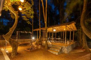 a pavilion with a table and a tree at night at Zostel Homes Bhor (Near Pune) in Pune