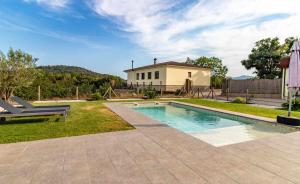 a swimming pool in the yard of a house at Can Pons De Dalt Casa rural a la Selva in Girona