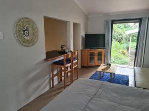 克盧夫的住宿－Lovely 1 Queen bed, 1 Sleeper couch Self-catering cottage，一间卧室配有一张床铺和一张桌子,还设有一间厨房