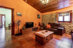 sala de estar con sofá y TV en Mas Roca Casa rural en entorno único en Girona