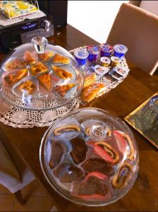 - une table avec deux assiettes de pâtisseries et quelques boissons dans l'établissement La Casa Di Ago, à LʼAquila