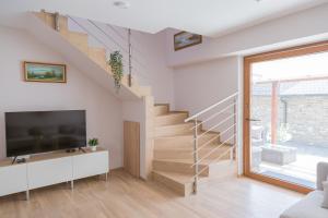 a living room with a staircase and a tv at Piros Vendégház in Tihany