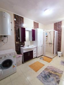 uma casa de banho com um lavatório e uma máquina de lavar roupa em KUZEY APART OTEL em Pazar
