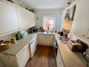 a kitchen with white cabinets and a counter top at Spacious Two Bedroom House - TM in Southport