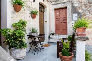 einer Haustür eines Hauses mit Topfpflanzen in der Unterkunft All’ombra del campanile in Tarquinia