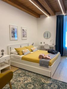 ein Schlafzimmer mit einem großen Bett mit gelber Bettwäsche in der Unterkunft All’ombra del campanile in Tarquinia
