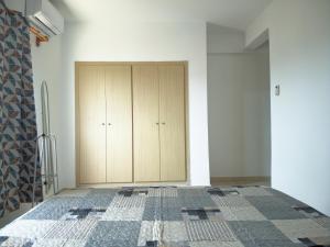um quarto com uma cama e um armário de madeira em Nomsa Zen Appartement em Abaga