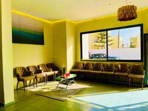 a living room with couches and a large window at Appart Hôtel Pyramides El Jadida in El Jadida