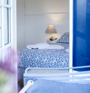 Habitación con vistas a un dormitorio con cama y lámpara. en Hotel Villa Brinkly en Snekkersten