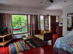 a bedroom with a bed and a couch and a table at Ltu Garden in Negril