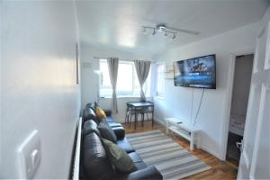 a living room with a couch and a table at London Zone 2 Two Bedroom Apartment in London