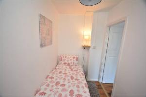 a bedroom with a bed with a flowered blanket at London Zone 2 Two Bedroom Apartment in London
