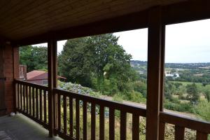 a view from the front porch of a house with a view of the countryside at Beautiful lake view 3 bedroom chalet. in Saint-Manvieu-Bocage