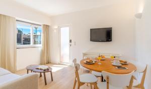uma sala de estar com uma mesa de jantar e um sofá em Pestana Alvor Beach Villas Seaside Resort em Alvor