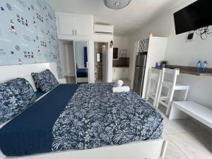 a bedroom with a blue and white bed and a kitchen at Costa Love Aparta Hotel in Punta Cana