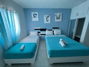 2 camas en una habitación con paredes azules en Costa Love Aparta Hotel en Punta Cana