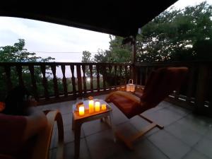 a patio with a chair and a table with candles at Spilidis House in Karavómilos
