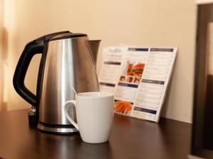 a coffee pot and a cup on a table at Bayside Hotel 100 Pixley Kaseme Street (West Street) in Durban