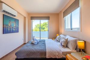 um quarto com uma cama grande e uma janela grande em Melograno 3-BR Apt w/ Terrace in Larnaca em Lárnaca