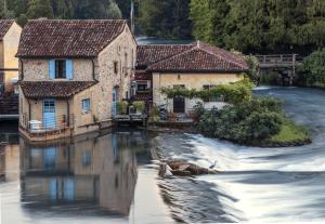 un grupo de edificios en un río con agua en Il Borghetto Vacanze nei Mulini, en Valeggio sul Mincio