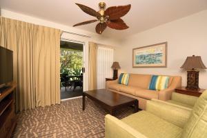 ein Wohnzimmer mit einem Sofa und einem TV in der Unterkunft Paniolo Greens Resort in Waikoloa