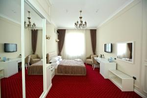 Habitación de hotel con cama y espejo en Miraj hotel en Baku