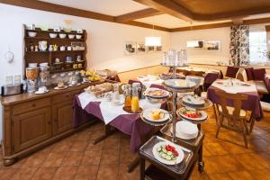 ein Esszimmer mit Tischen und Teller mit Lebensmitteln in der Unterkunft Gästehaus Sunkler in Golling an der Salzach
