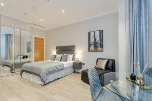 1 dormitorio con 1 cama, 1 silla y 1 sofá en Cleveland Residences Chelsea, en Londres