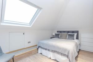 a bedroom with a bed and a large window at Cleveland Residences Chelsea in London