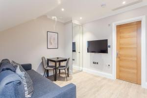 a living room with a blue couch and a table at Cleveland Residences Chelsea in London