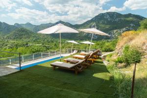 un patio con sillas y sombrillas y una piscina en Brioni, en Virpazar