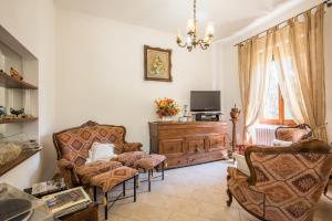 uma sala de estar com duas cadeiras e uma televisão em Villa in Pineta em Sinalunga
