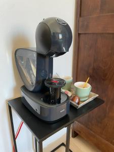Les Hirondelles de la villa des roses في Pontmain: وجود آلة صنع القهوة على طاولة