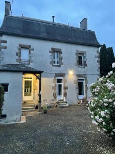 una grande casa bianca con una porta gialla di Les Hirondelles de la villa des roses a Pontmain