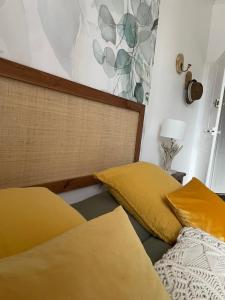 1 dormitorio con 2 camas con almohadas amarillas en Les Hirondelles de la villa des roses en Pontmain