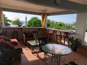 een kamer met een bar met stoelen en tafels bij Airport Beach Hotel in Montego Bay