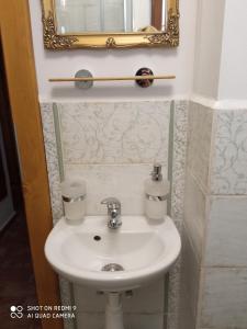 lavabo blanco en el baño con espejo en Pension Fanlor, en Zubčická Lhotka