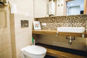 a bathroom with a white toilet and a sink at Apartament przy parku in Radom