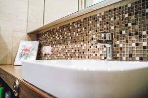 a white sink in a bathroom with a mirror at Apartament przy parku in Radom
