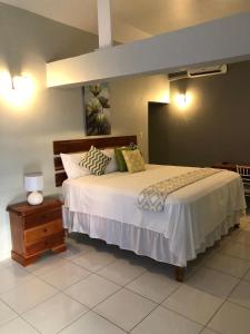 um quarto com uma cama grande e uma mesa de cabeceira em Airport Beach Hotel em Montego Bay