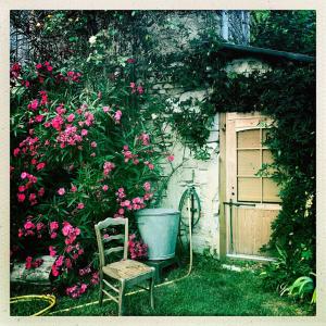 a chair sitting in front of a building with flowers at Roulotte Tzigane au bord du ruisseau - Drôme Provençale (2p) in Marsanne