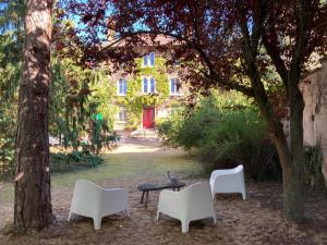un gruppo di sedie e un tavolo di fronte a un edificio di Appartement Villa Medreville a Nancy
